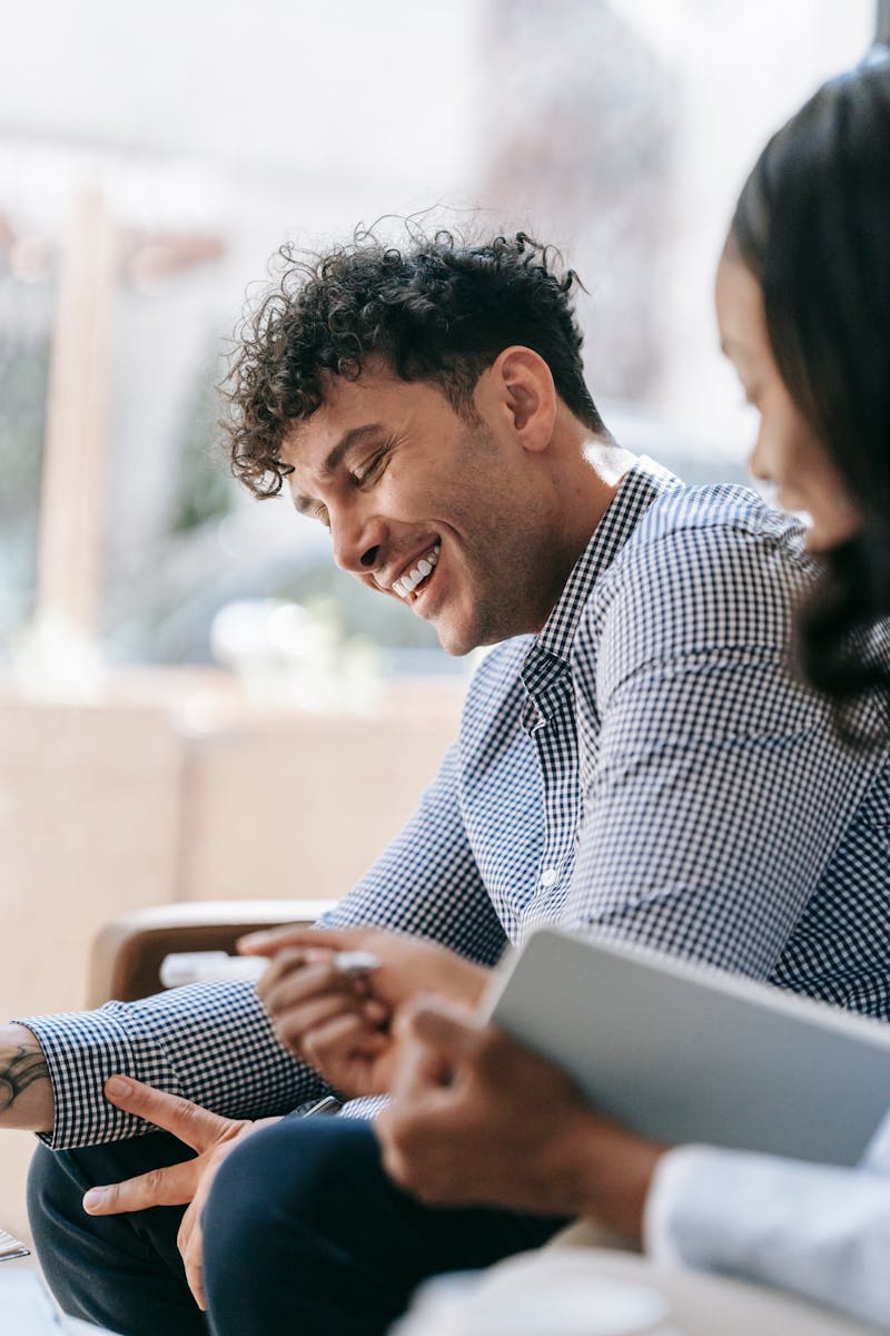 Smiling man with curly hair engaging in a conversation indoors.
